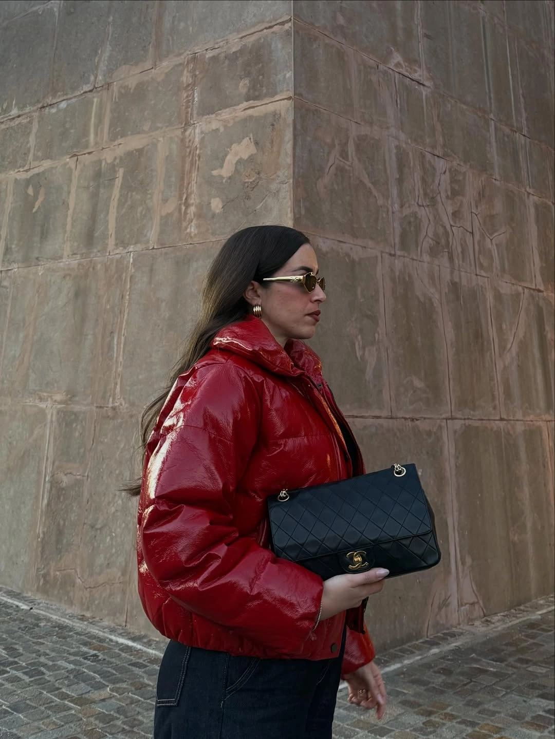 Glossy red puffer with dark denim and black quilted bag