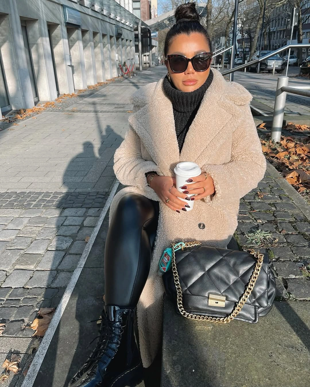 Beige textured outer layer with black turtleneck and glossy bottoms