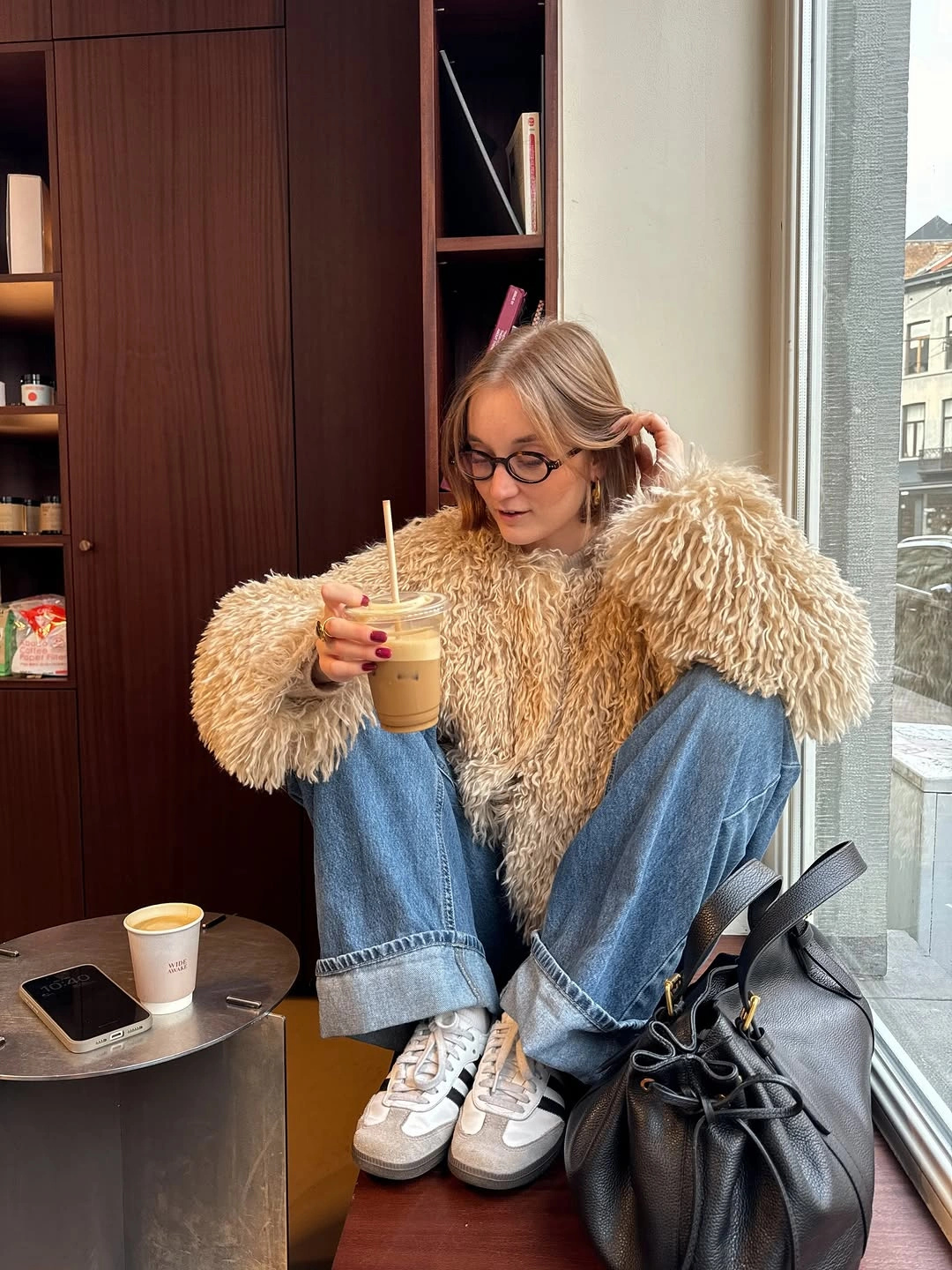 Shaggy beige jacket with cuffed blue jeans and light sneakers