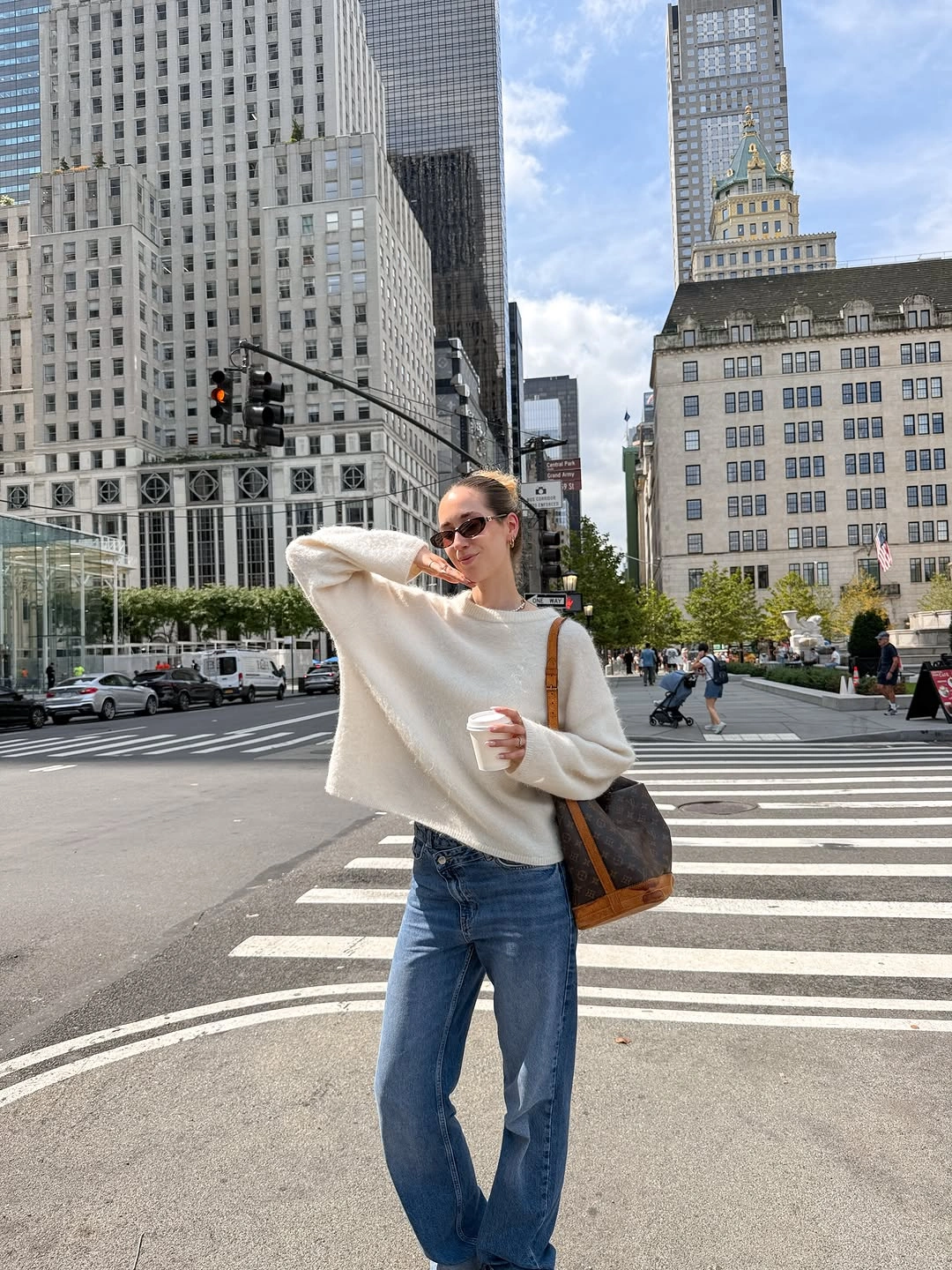 Loose cream sweater with relaxed jeans and brown shoulder tote