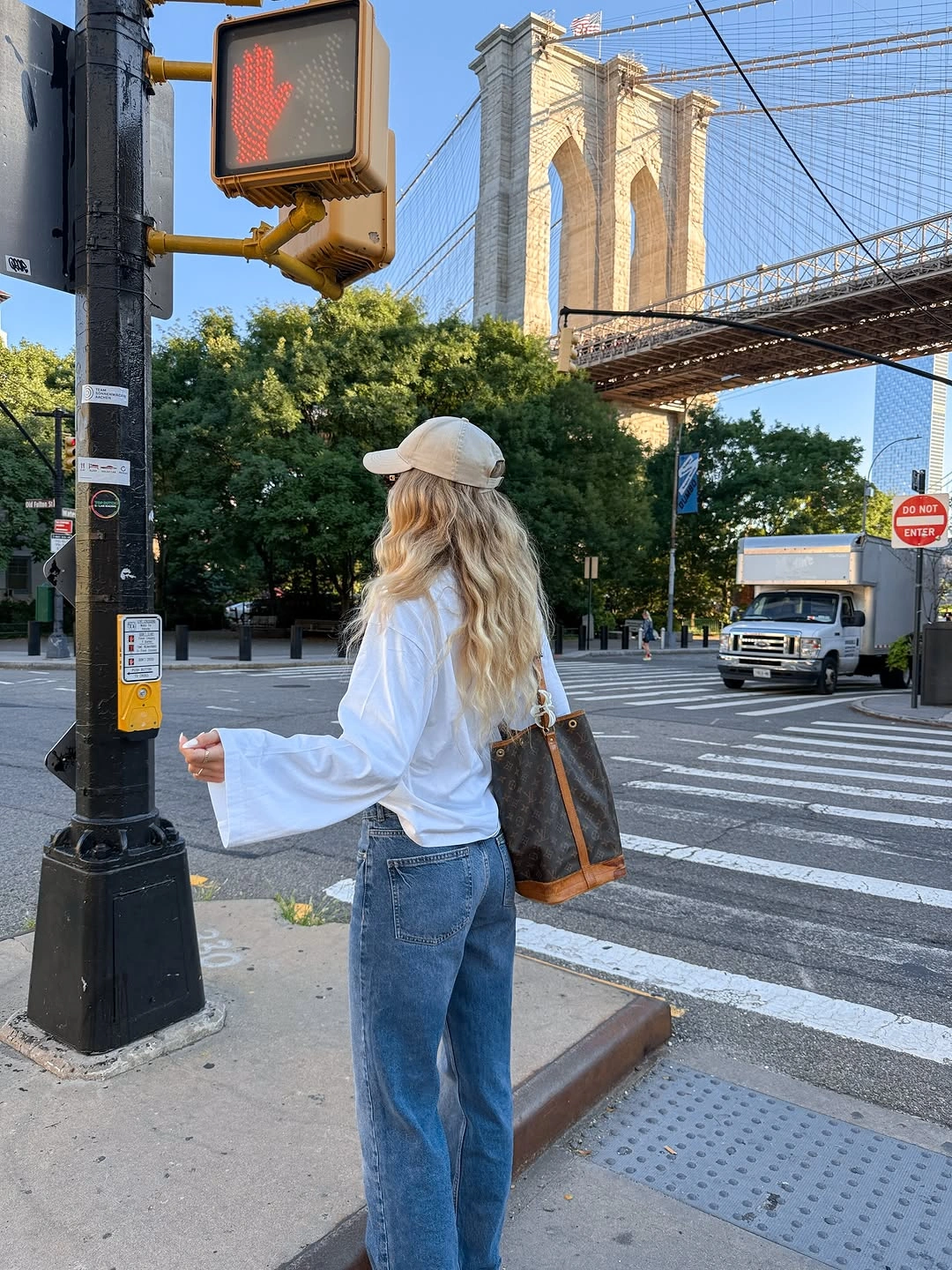 White loose top with relaxed jeans and pale baseball cap