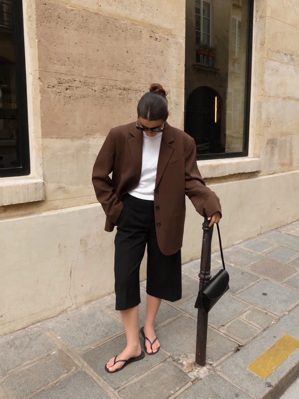 Brown oversized blazer with black long shorts and flip-flops