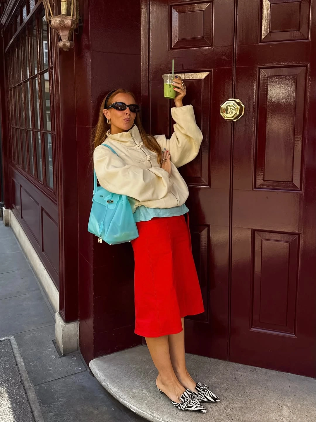 Cream pullover with red skirt turquoise bag and zebra flats