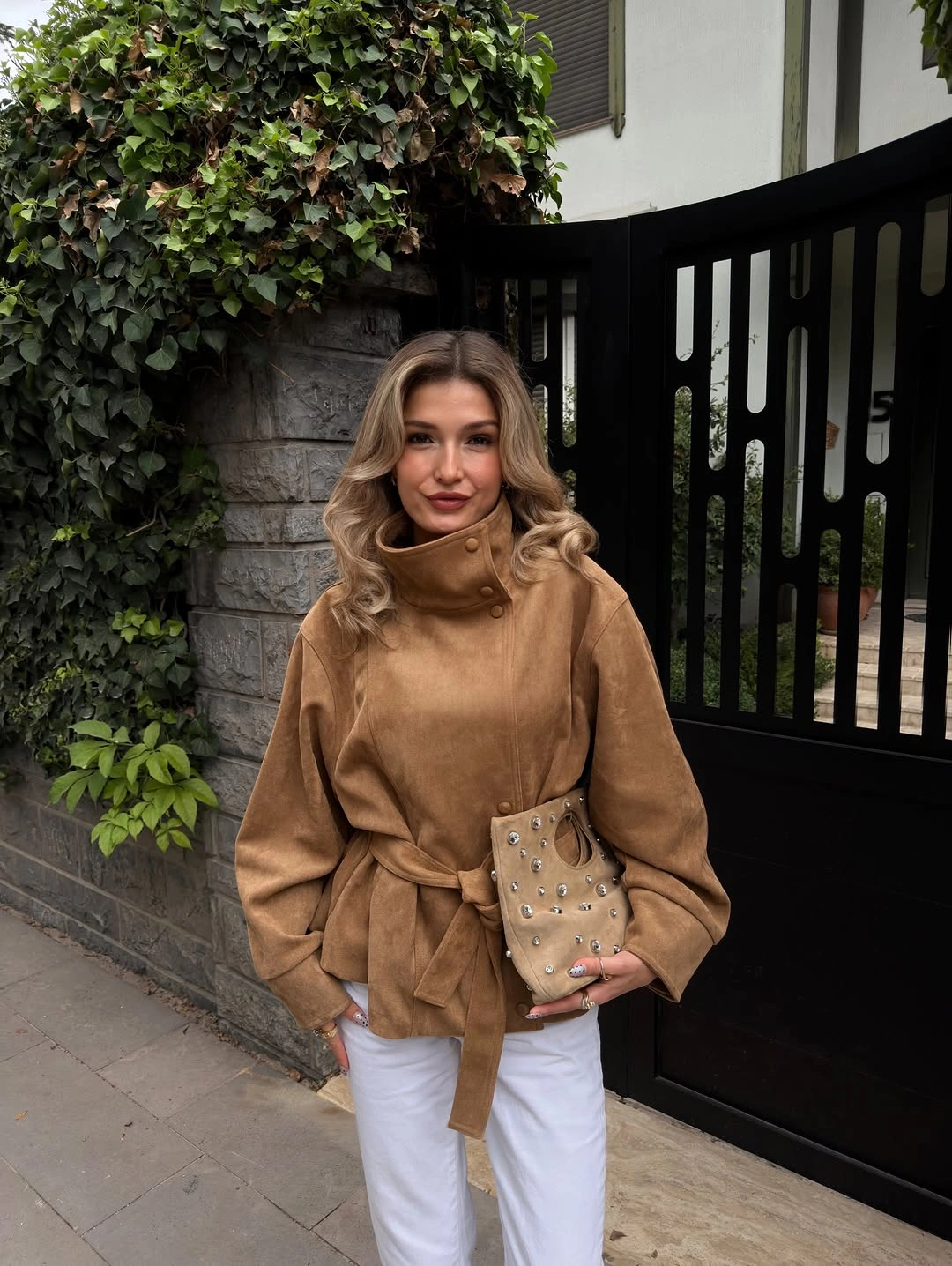 Camel belted jacket with white trousers and embellished clutch