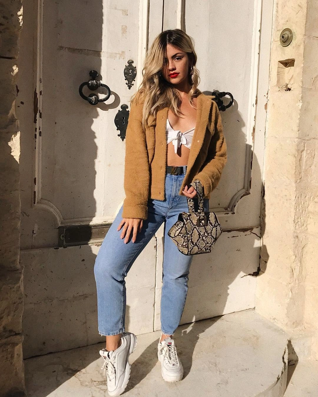 Caramel cropped jacket with light jeans and white sneakers