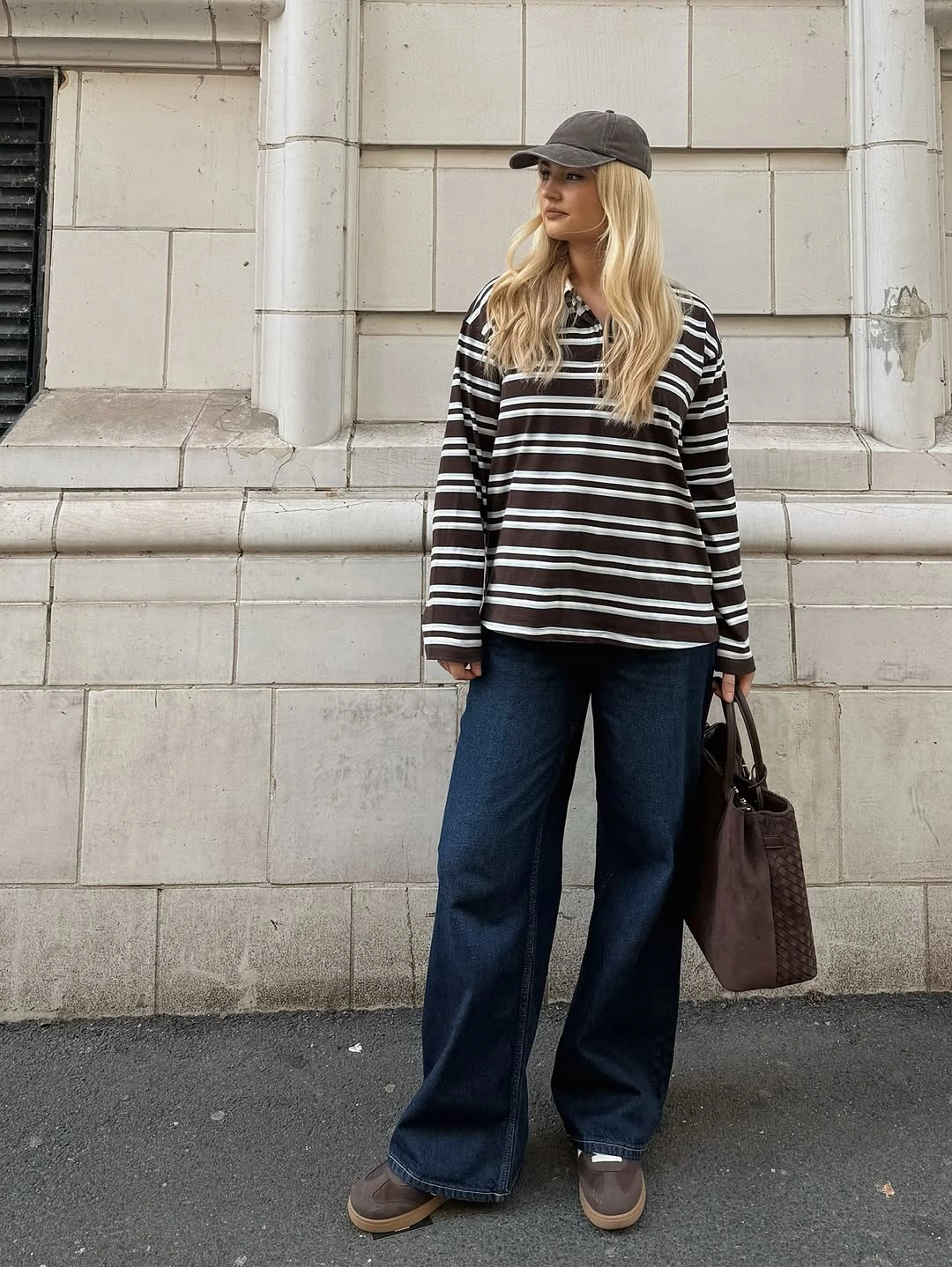 Striped collared top with dark wide-leg jeans and cap