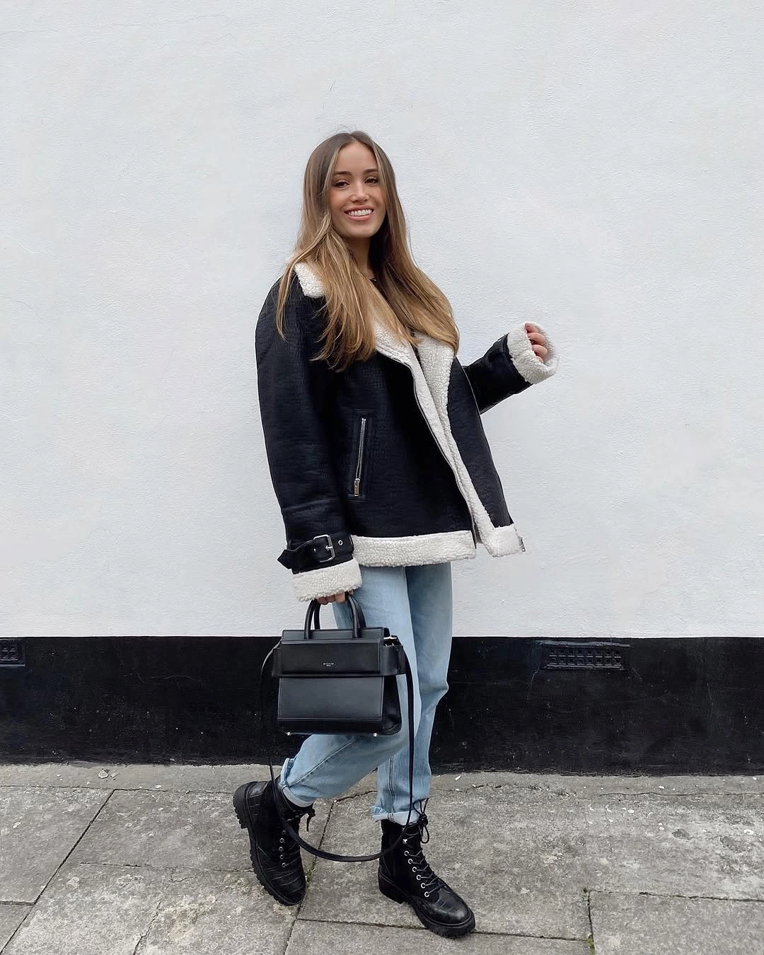 Black jacket with ivory fuzzy trim and pale slim jeans
