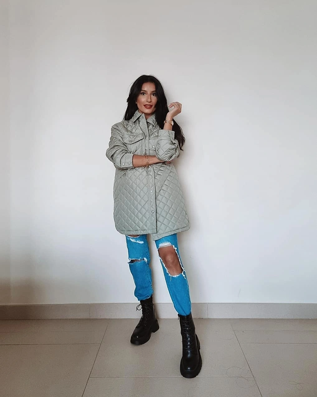 Gray quilted shirt-jacket with ripped jeans and black lace-up boots
