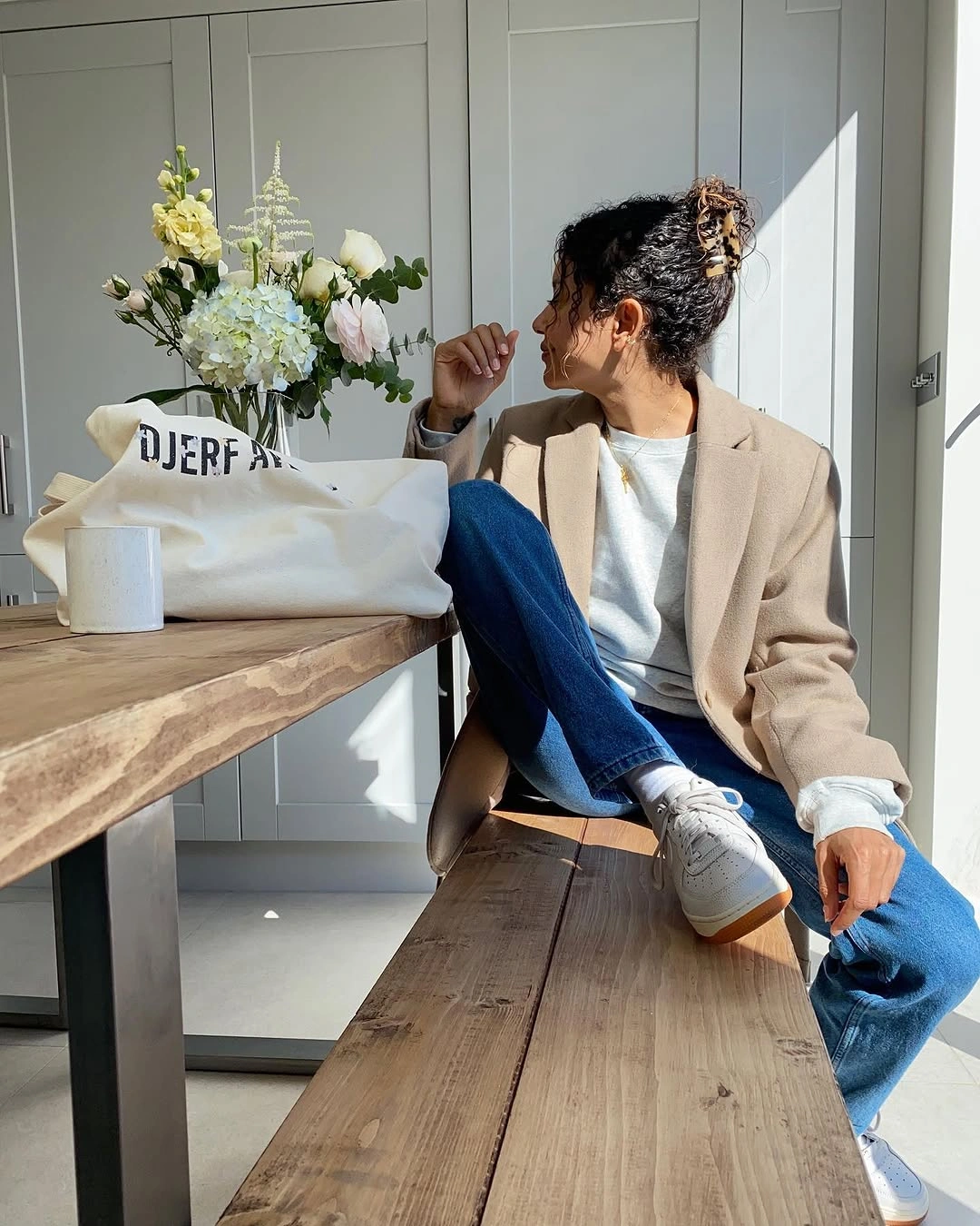 Taupe blazer with white top, blue jeans, and white sneakers