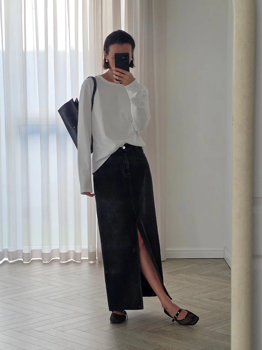 Loose white long-sleeve top with black maxi skirt and flat sandals