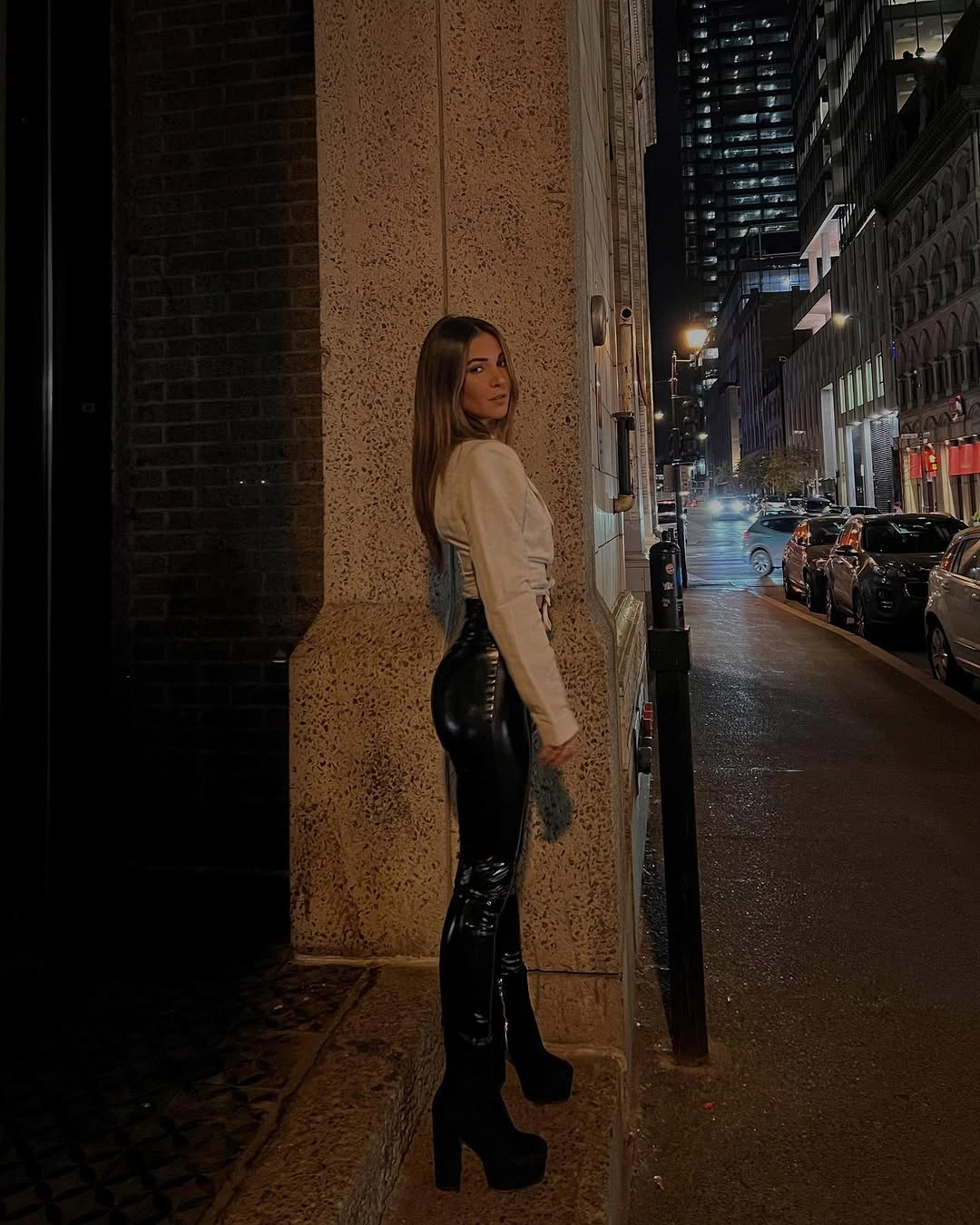 Pale long-sleeve top with glossy black fitted trousers and platform boots