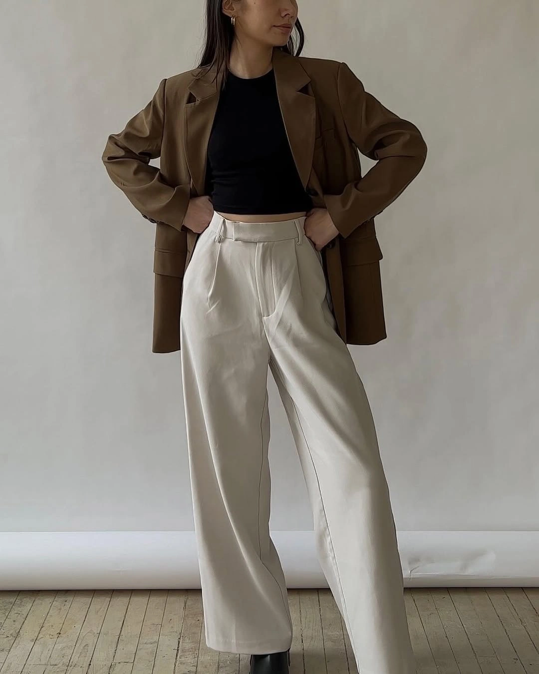 Oversized brown blazer with cropped black top and cream wide-leg trousers