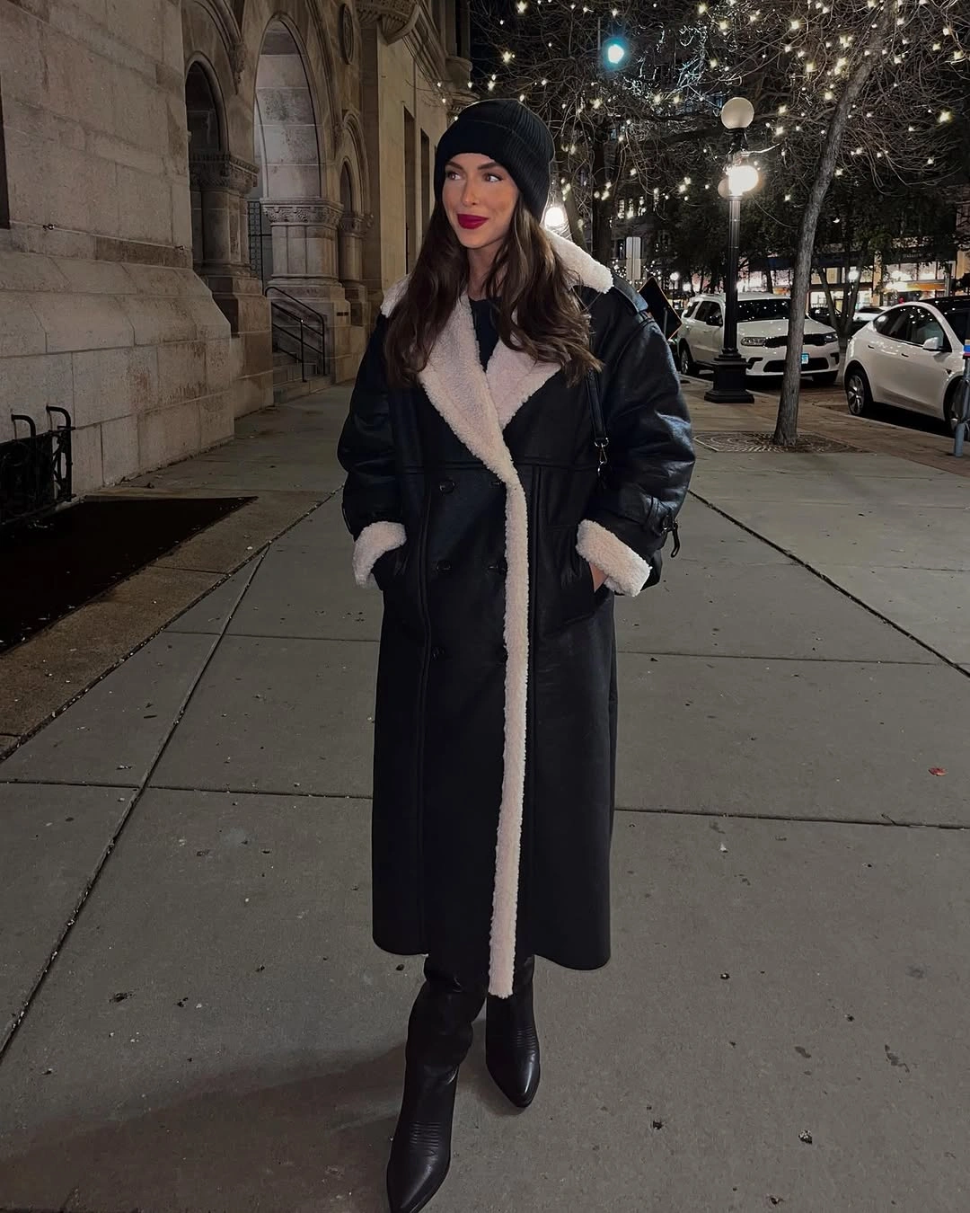 Long black coat with cream fuzzy trim, beanie, and pointed boots