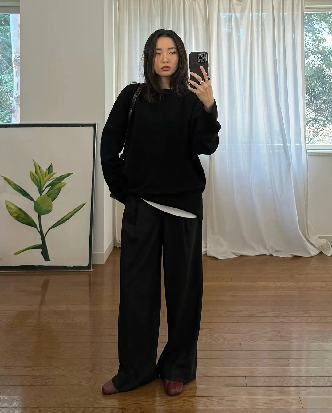 Oversized black sweatshirt and wide trousers with white waist accent and burgundy shoes