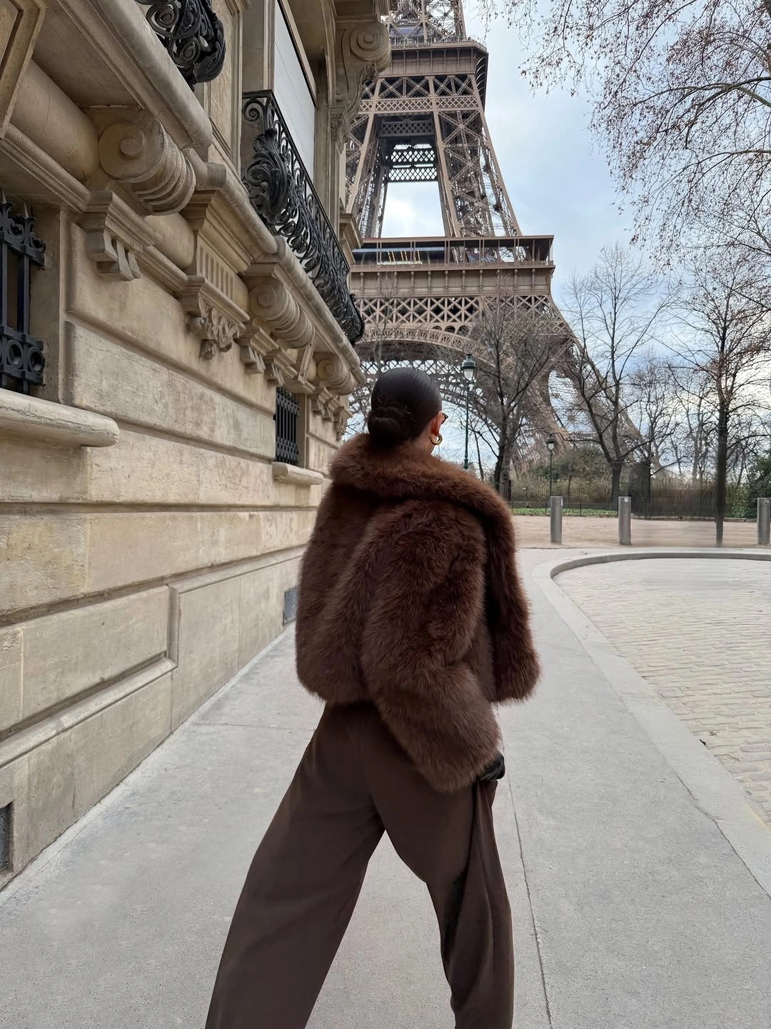 Voluminous dark brown shaggy jacket paired with wide brown trousers