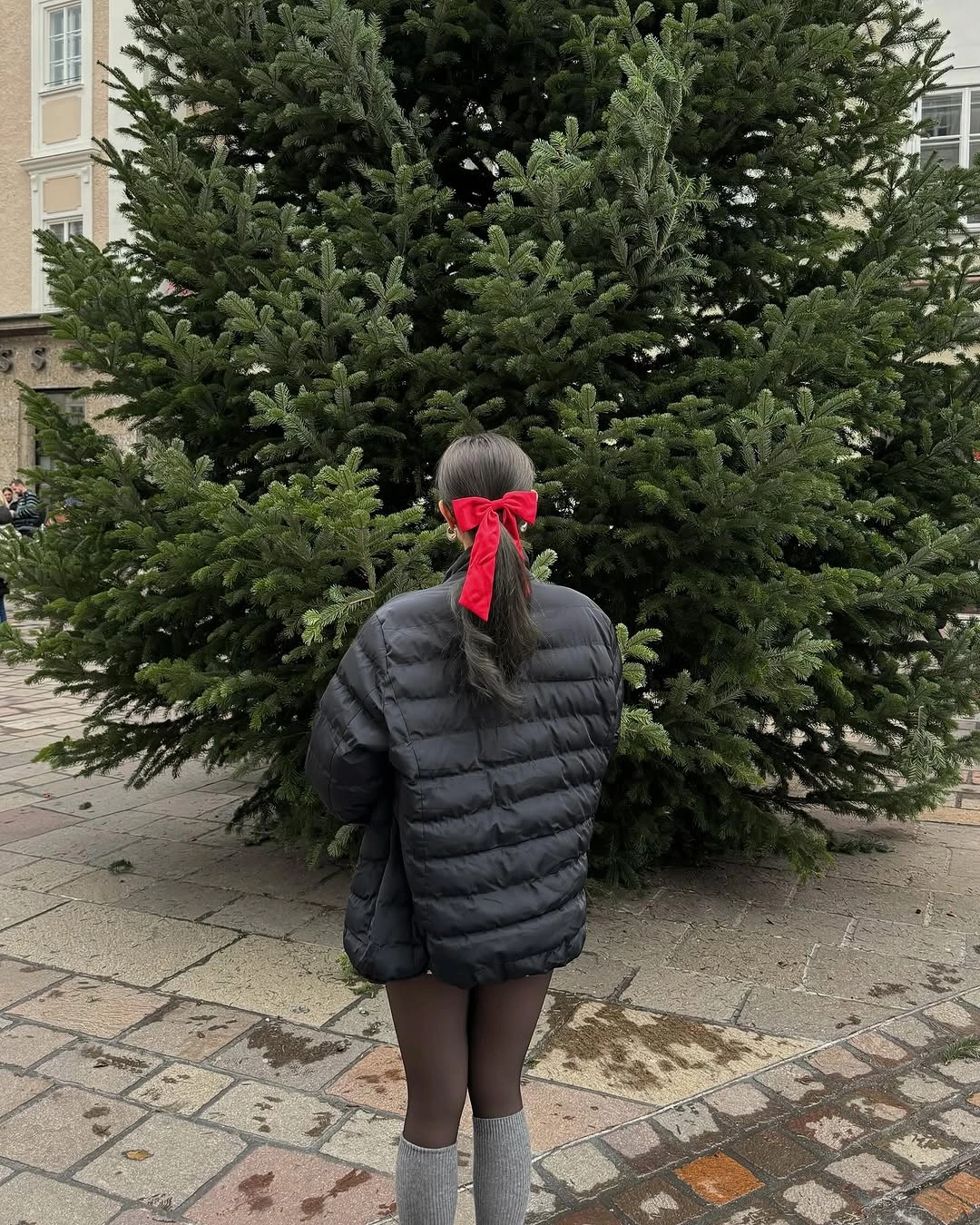 Charcoal quilted puffer with dark tights, gray socks, and red hair ribbon