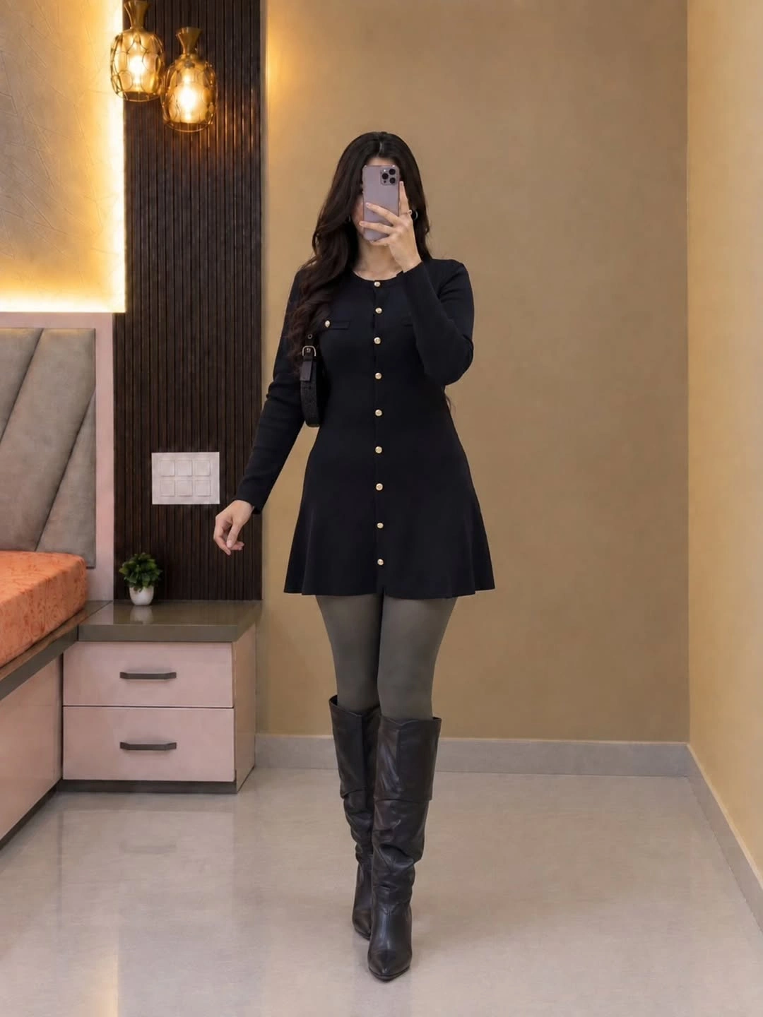 Black long-sleeved dress with gold buttons, gray tights, and tall boots