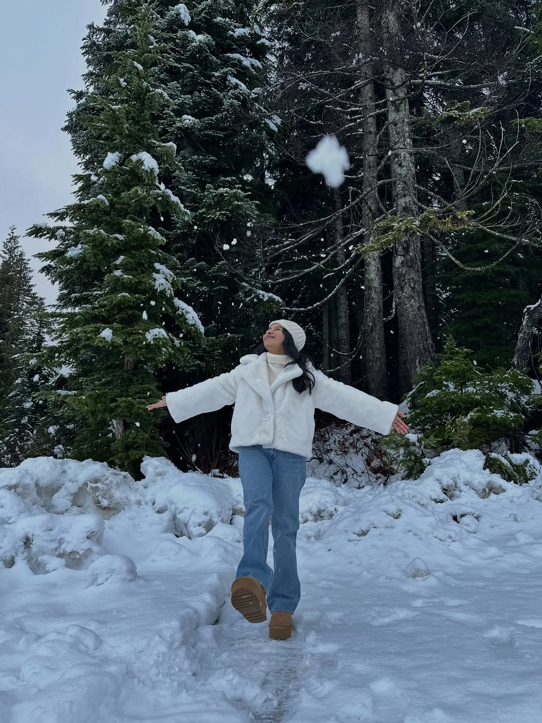 Short textured white jacket, white scarf, pale blue jeans, and tan footwear