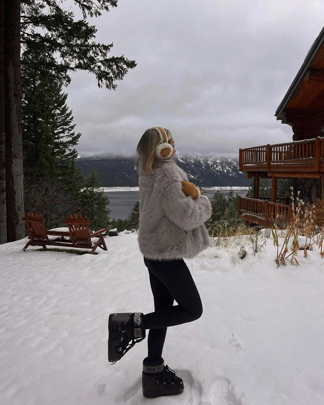 Short gray shaggy jacket, black leggings, chunky boots, and round earmuffs