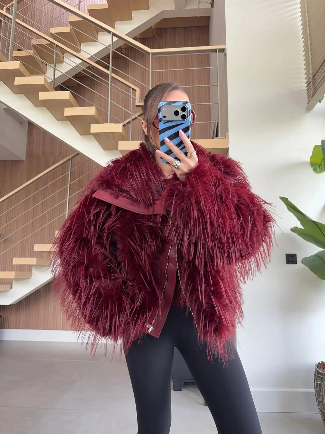 Burgundy shaggy cropped jacket over black leggings in an indoor mirror selfie