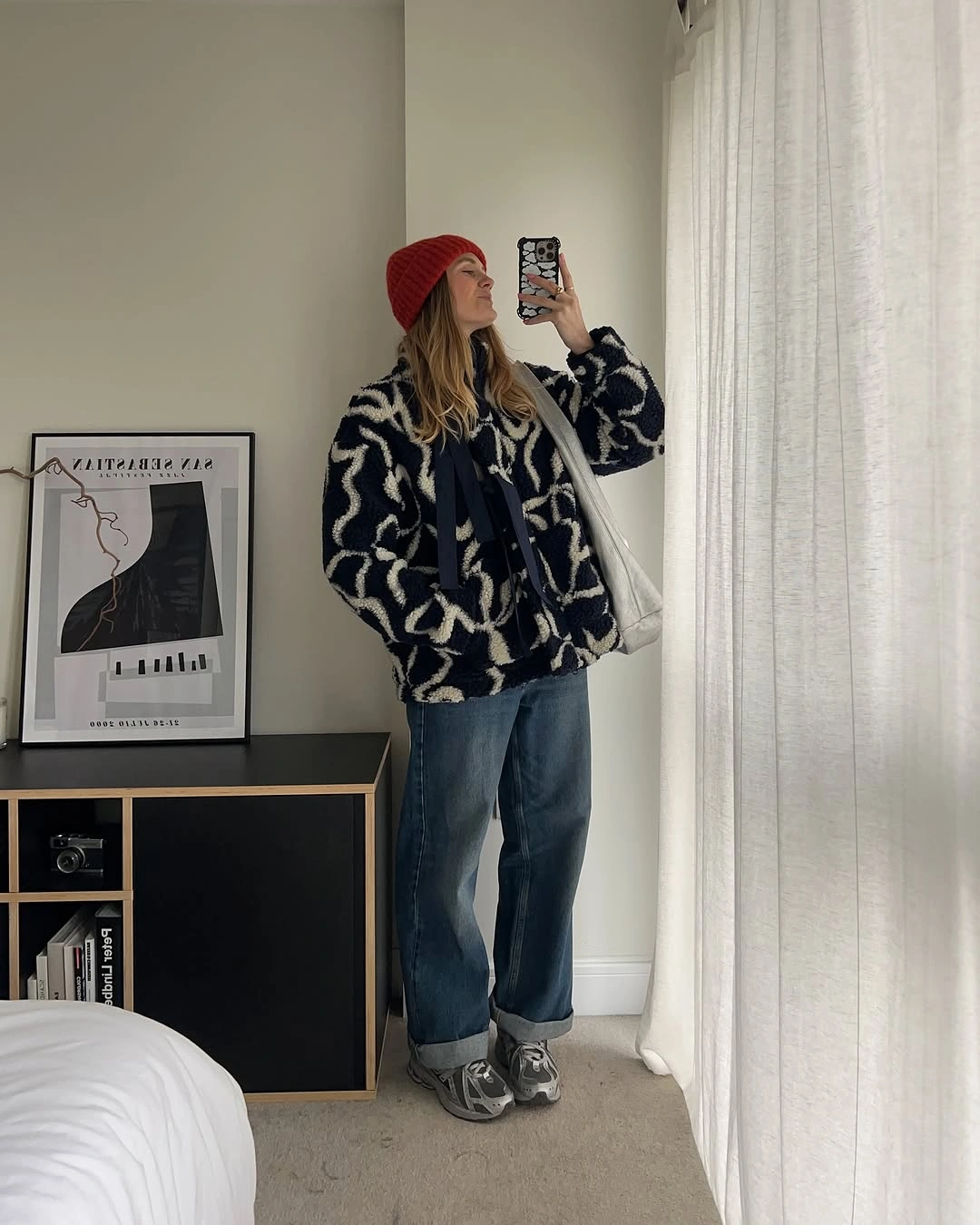 Oversized black and ivory patterned jacket with cuffed jeans and red beanie