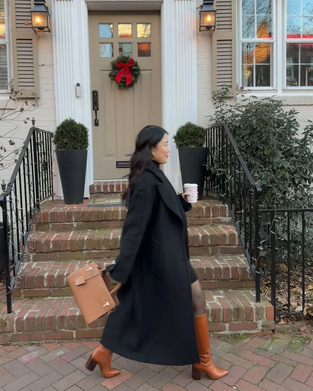 Long dark coat with cognac knee high boots and structured tan handbag