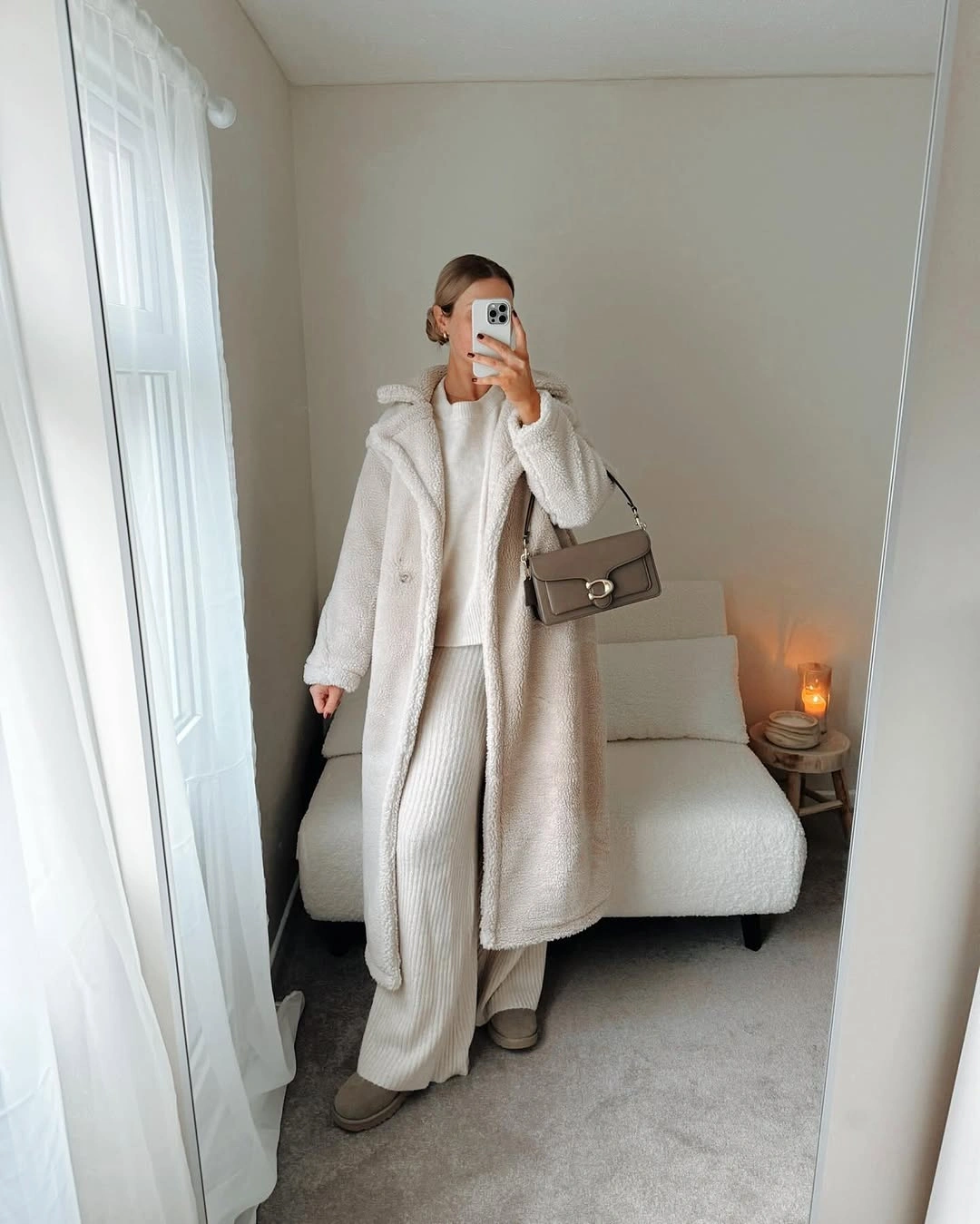 Long cream textured coat with ivory ribbed trousers and taupe shoulder bag