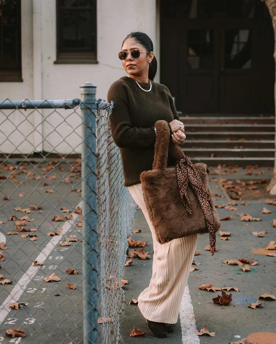 Brown ribbed sweater with pale vertically textured lower garment and fuzzy tote