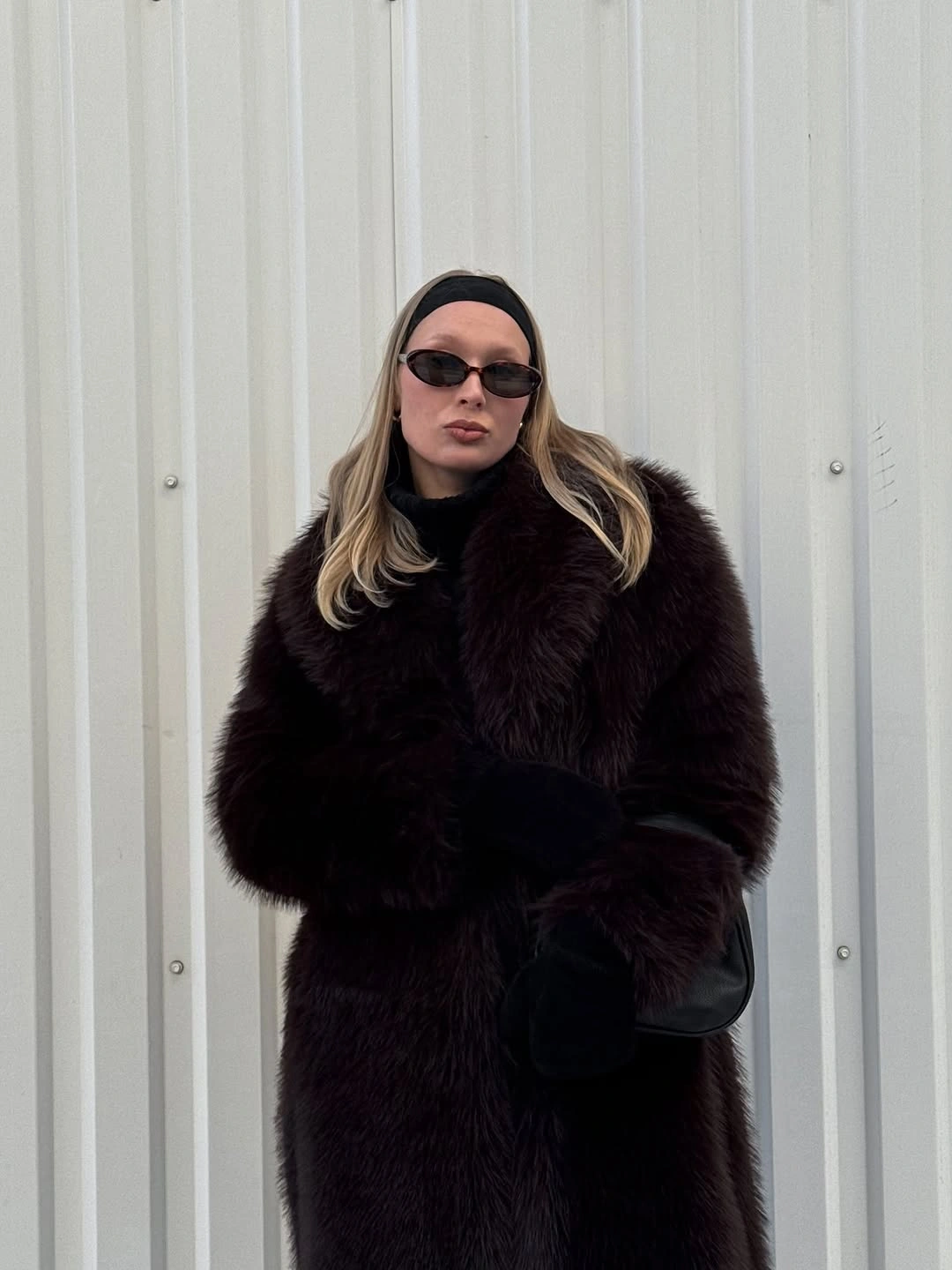 Dark plum brown textured coat with black headband and narrow sunglasses