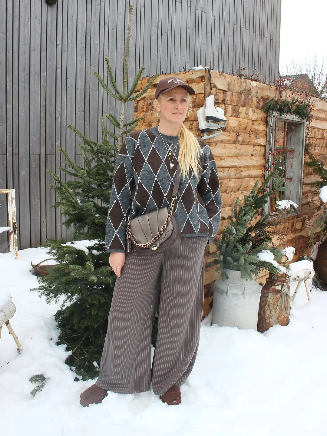 Gray argyle sweater, wide gray pants, brown cap, crossbody bag, and shoes.