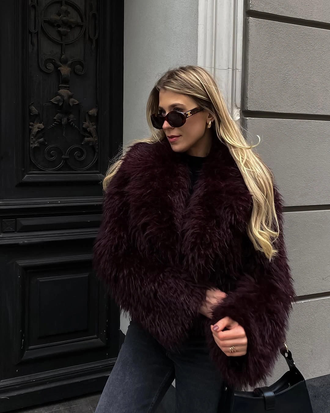 Deep burgundy shaggy jacket, black top, charcoal jeans, and dark sunglasses.