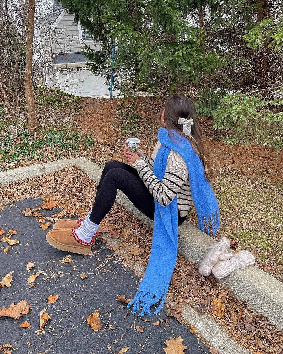 Bright blue scarf over striped top, black leggings, striped socks, and tan shoes.