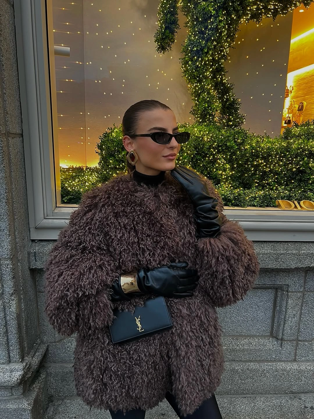 Dark brown shaggy jacket, black gloves, sunglasses, and small black handbag