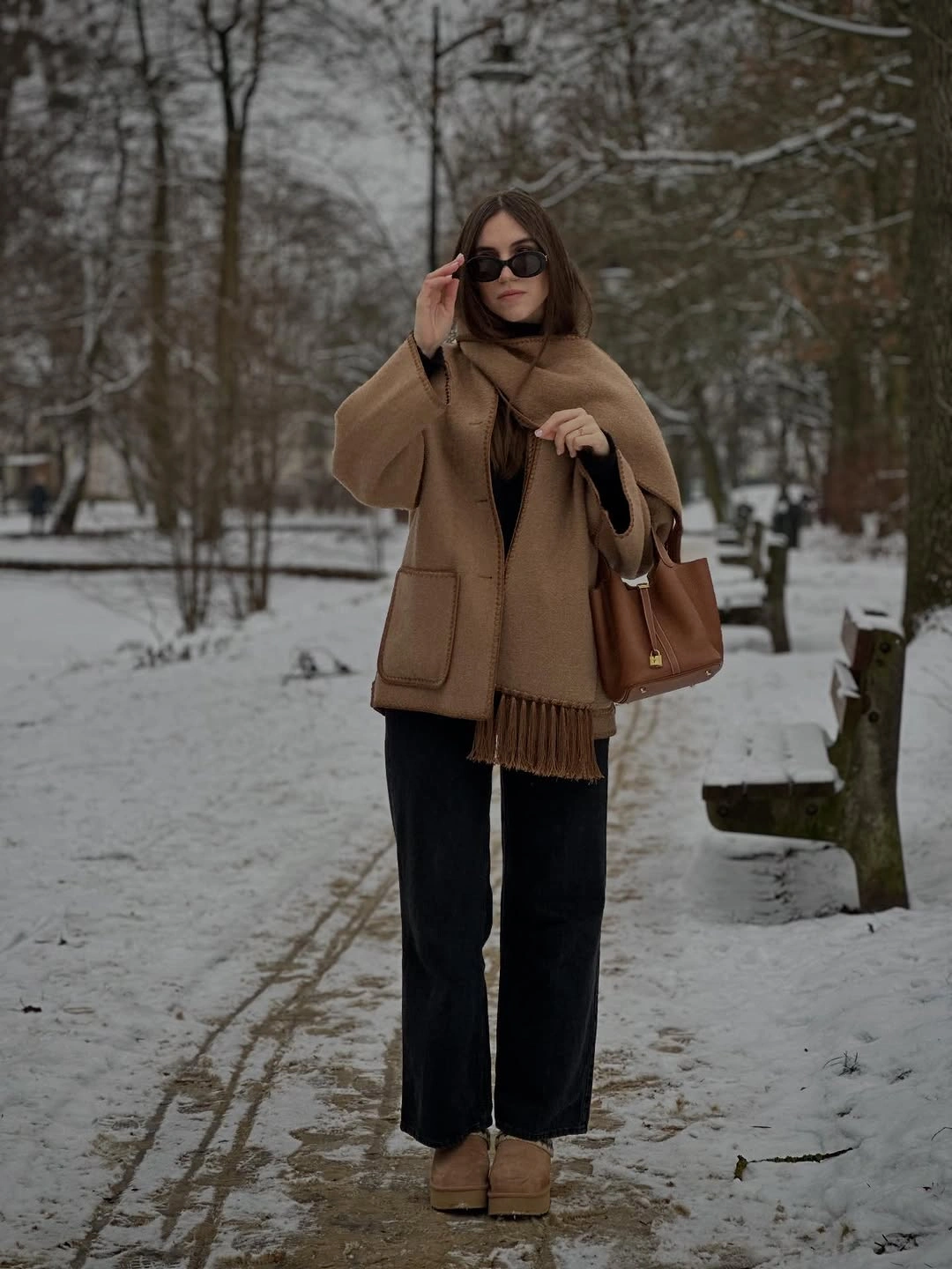 Camel coat, matching scarf, black wide-leg pants, and tan shoes