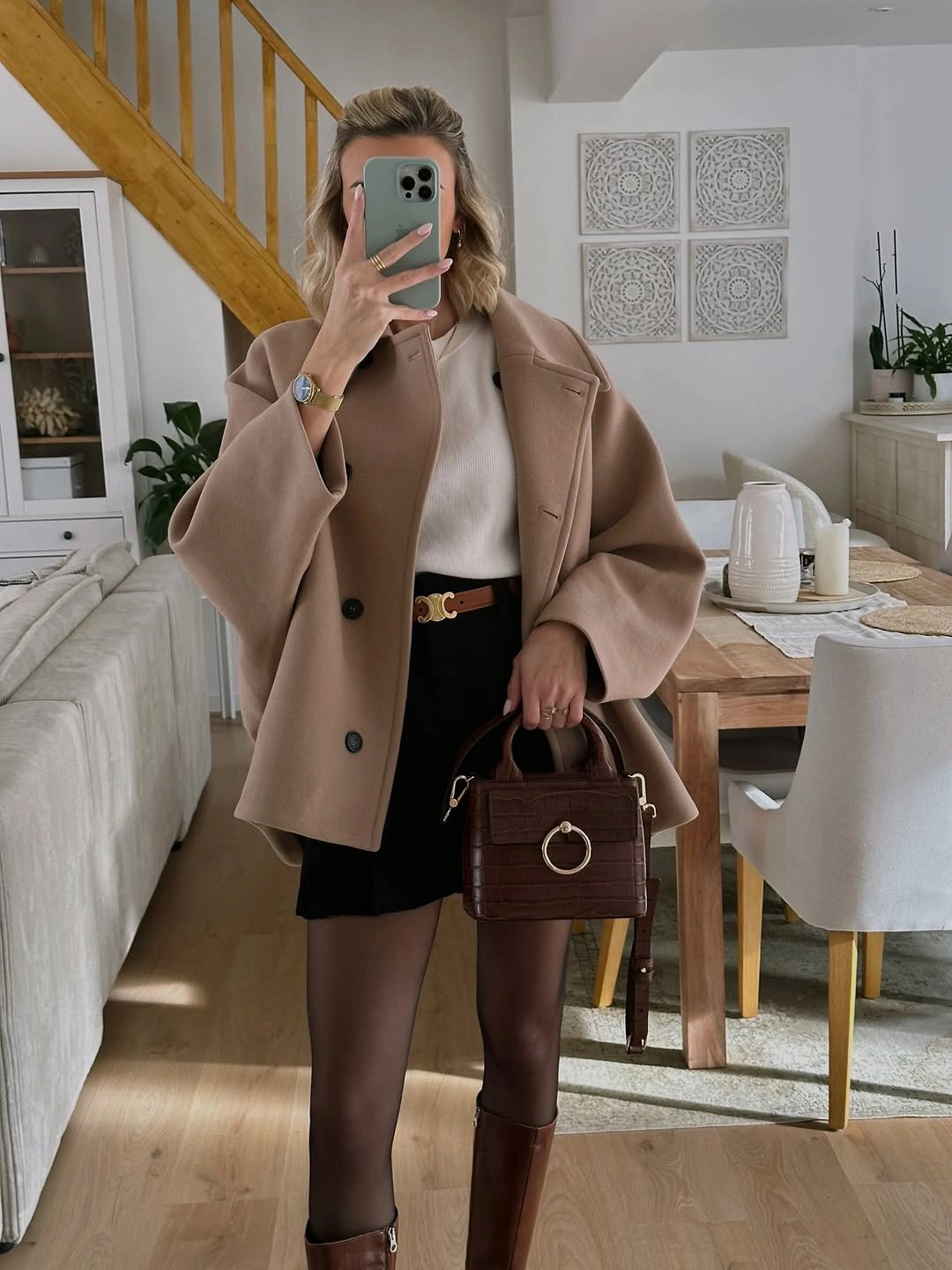 Camel jacket, cream sweater, black mini skirt, sheer tights, and brown boots