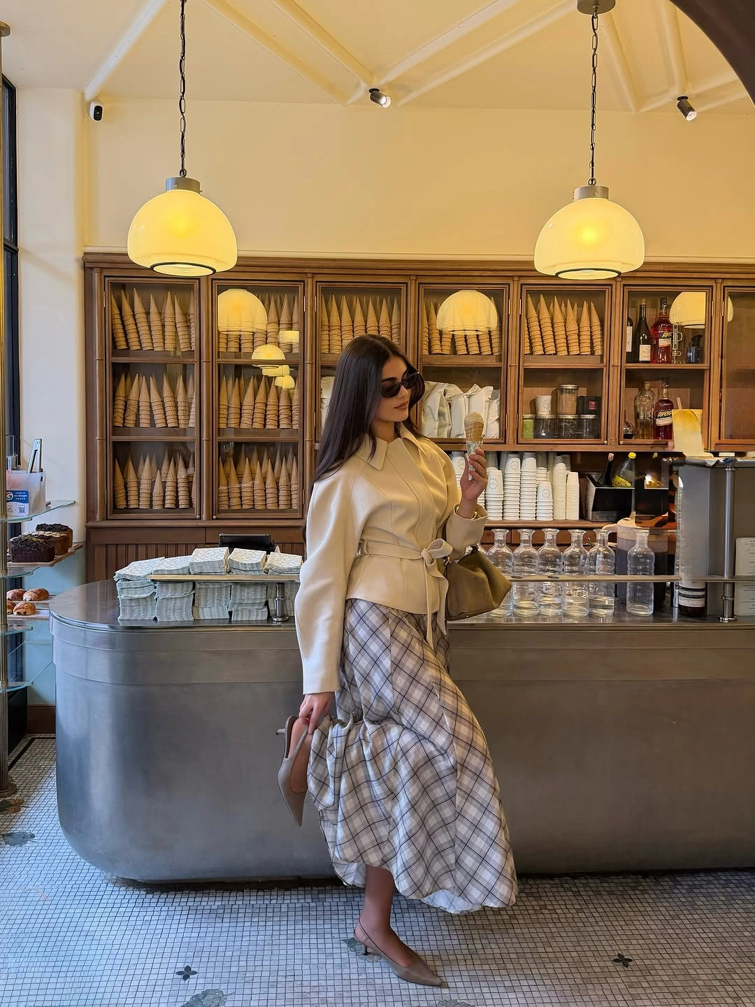 Cream long-sleeved top, long plaid skirt, and neutral pointed flats
