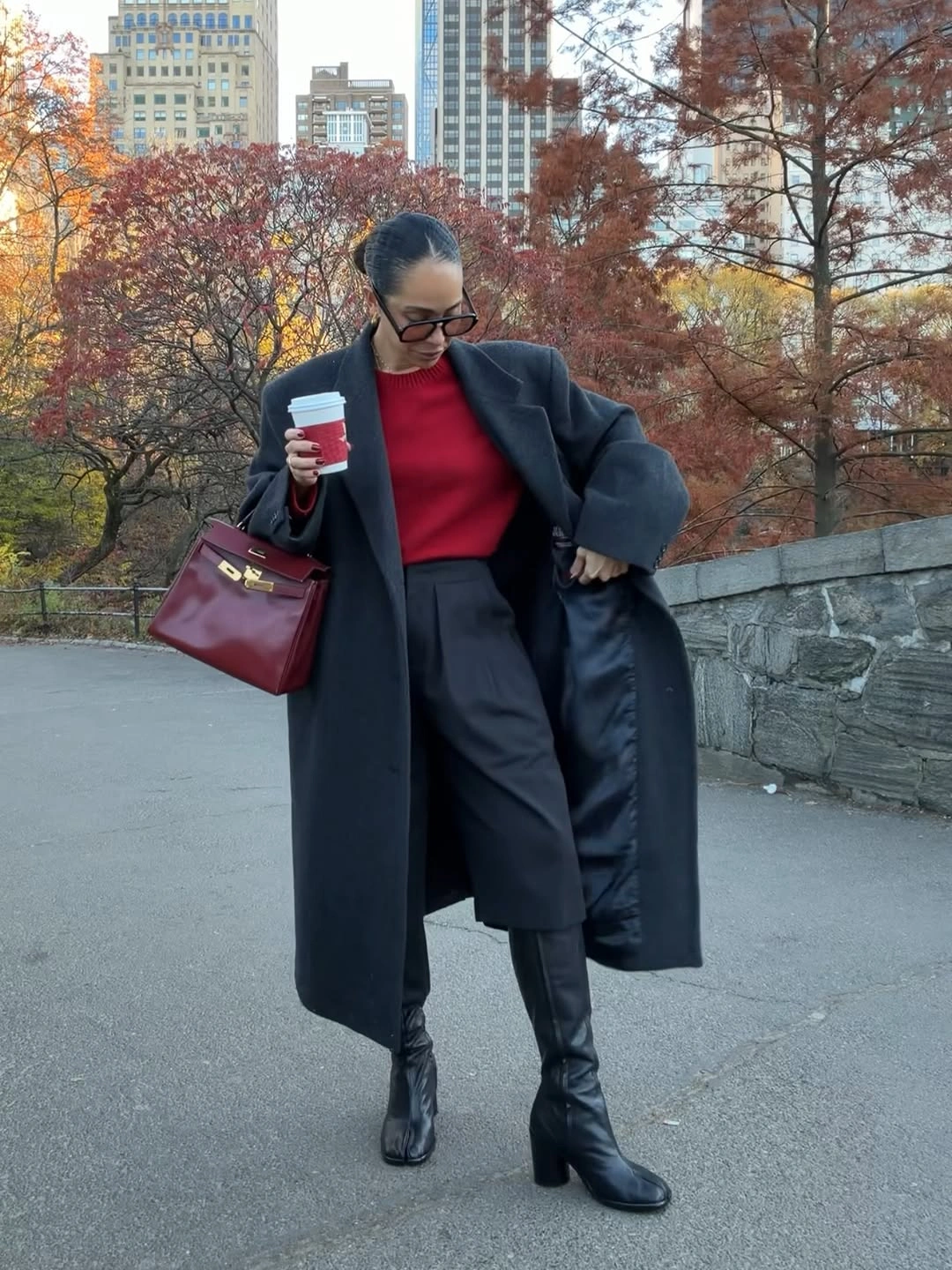 Black coat with red sweater, long shorts and tall boots