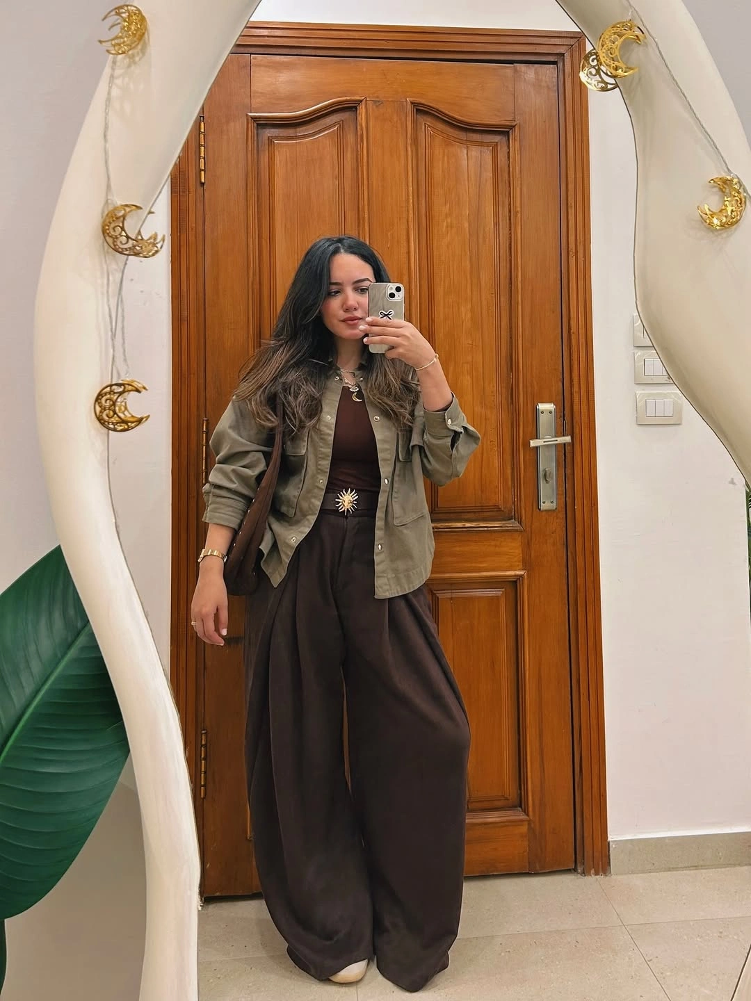 Olive utility-style jacket with brown top and wide trousers