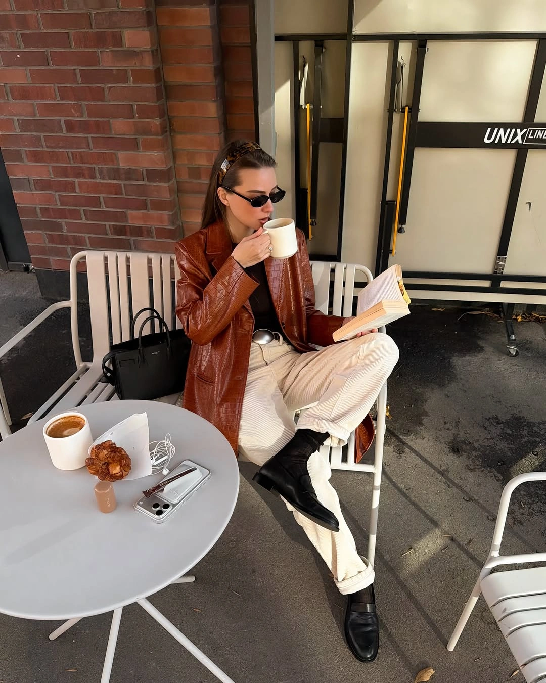Cognac-brown leather-look blazer with cream wide trousers and black loafers