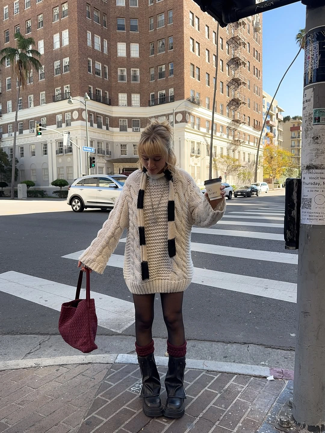 Cream cable-knit sweater with sheer tights, black boots and burgundy tote